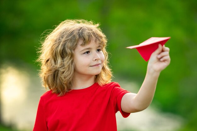 Il ragazzo divertente del bambino sogna di diventare un aviatore giocando all'aereo di carta crescita all'aperto concetto di bambini felice chil