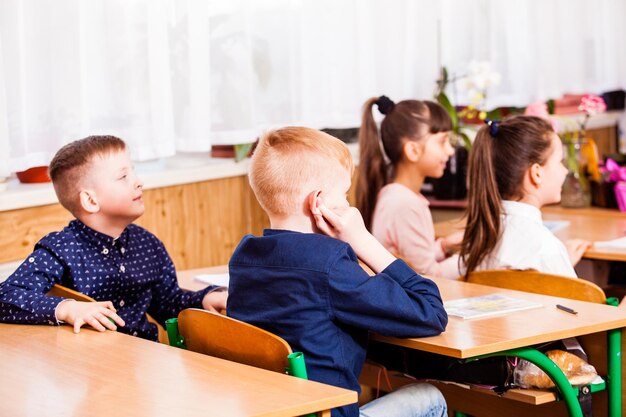 Il ragazzo divertente ha chiuso le orecchie sulla lezione. Orario scolastico molto noioso