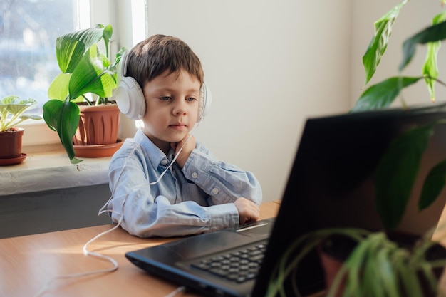 Il ragazzo è impegnato nell'istruzione online Formazione online Istruzione a casa Un laptop Bambino e tecnologia Un articolo sulla scelta dell'istruzione per un bambino