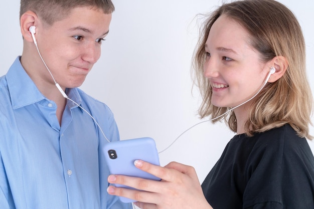 Il ragazzo e la ragazza dell'adolescente ascoltano la musica da un auricolare Primo concetto di amore