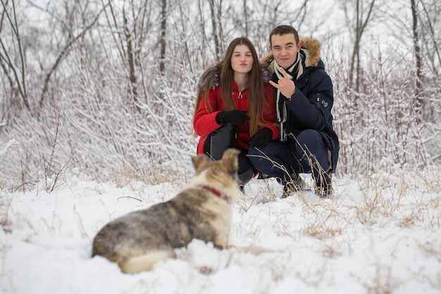 Il ragazzo e la ragazza si riposano nei boschi d'inverno Marito e moglie nella neve Giovane coppia che cammina nel parco invernale