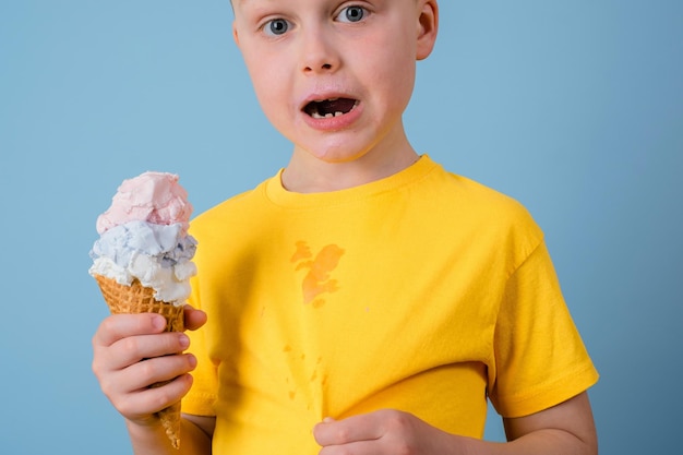 Il ragazzo è sorpreso di macchie sporche di gelato sui tuoi vestiti su sfondo blu