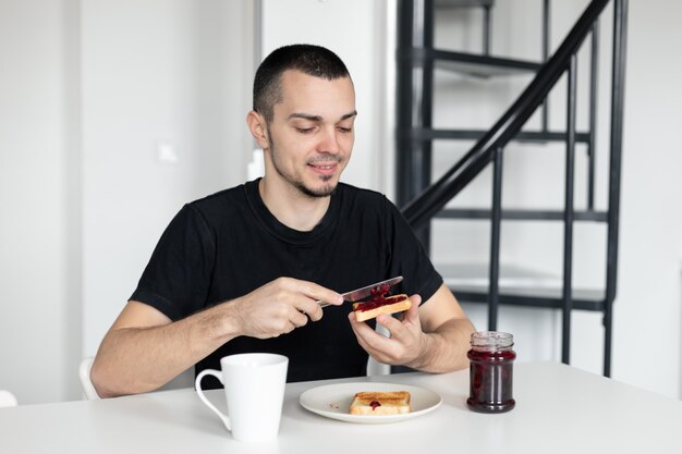 Il ragazzo fa colazione con toast con marmellata.