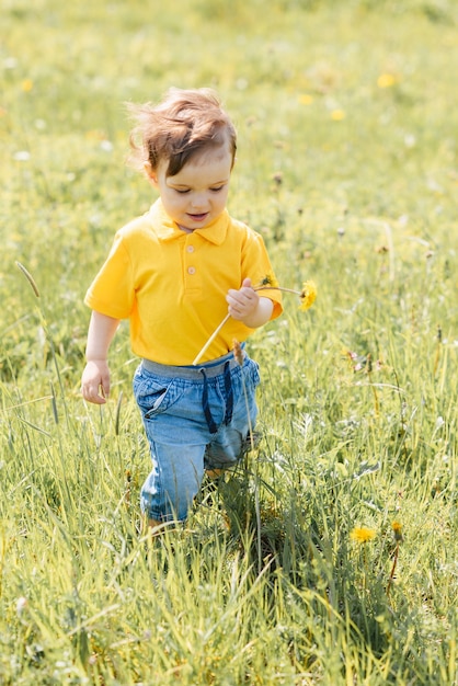 Il ragazzo felice corre e gioca all'aperto in un campo