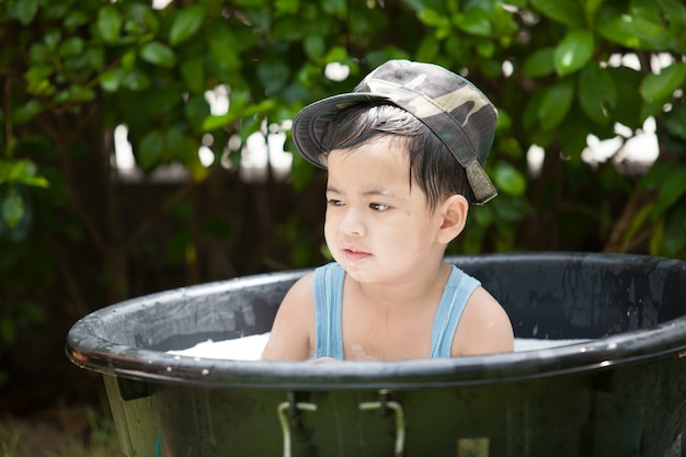 Il ragazzo gioca con acqua nel giardino.