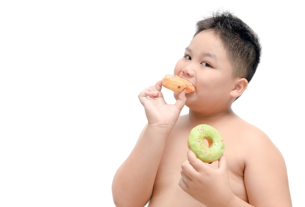 Il ragazzo grasso obeso sta mangiando la ciambella isolata