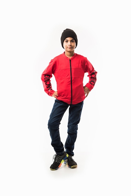 Il ragazzo indiano indossa una giacca invernale, in piedi isolato su sfondo bianco