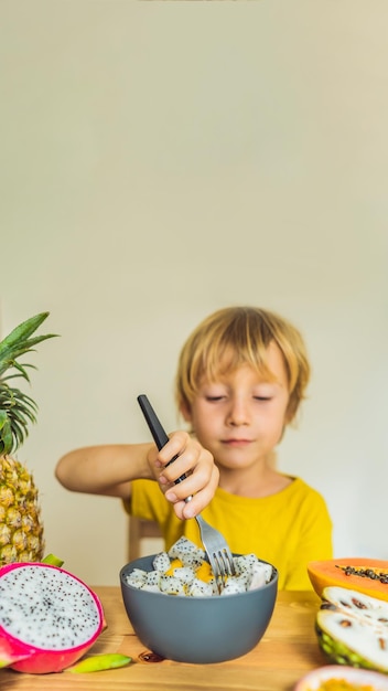 Il ragazzo mangia frutta cibo sano per bambini bambino che mangia spuntino sano nutrizione vegetariana per bambini