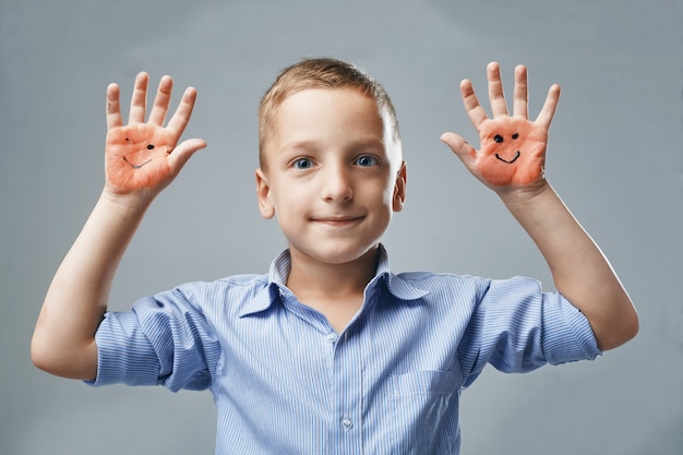 Il ragazzo mostra la mano con emoticon disegnate