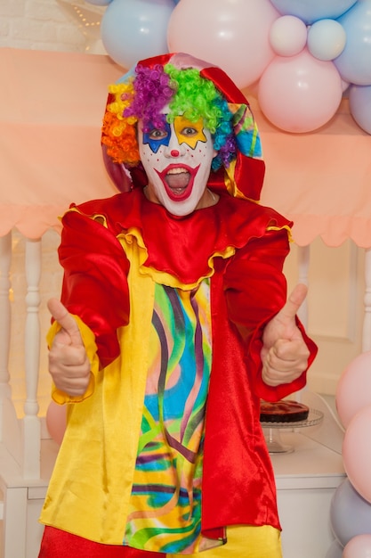 Il ragazzo pagliaccio alla festa per bambini mostra la classe