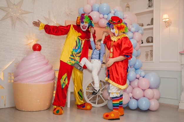 Il ragazzo pagliaccio con la ragazza pagliaccio si diverte alla celebrazione con i bambini Felicità dei bambini