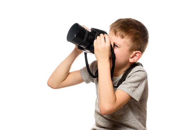 Il ragazzo scatta foto con la fotocamera. Ritratto. Isolare su sfondo bianco.