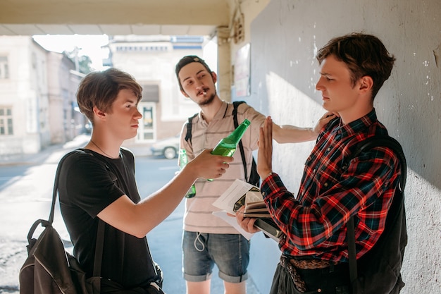 Il ragazzo sfigato resiste alle cattive influenze. concetto di cattive abitudini di dipendenza da fumo adolescenziale. Stile di vita giovanile urbano moderno