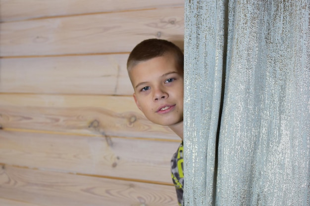 Il ragazzo si nasconde dietro una tenda nella stanza. i bambini nascondono e cercano