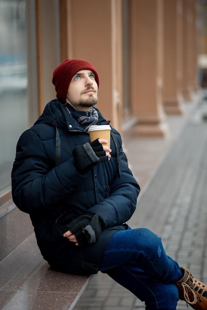 Il ragazzo sta bevendo un caffè in città