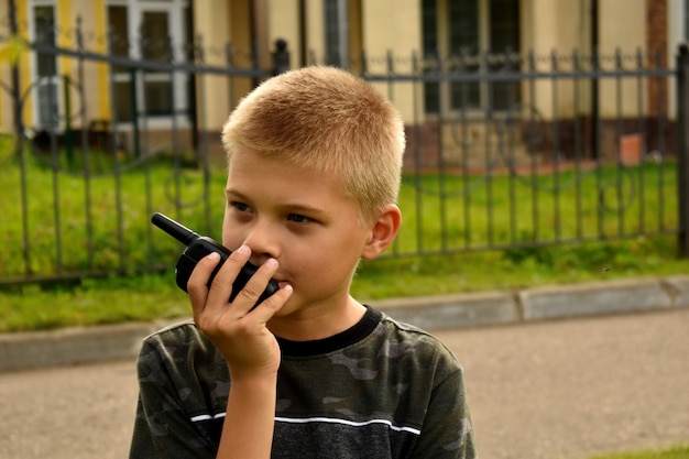 Il ragazzo sta parlando al walkie-talkie. Giochi di guerra da ragazzo.