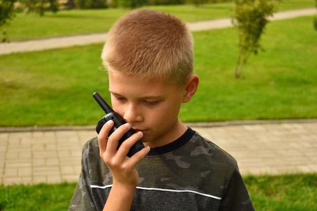 Il ragazzo sta parlando al walkie-talkie. Walkie-talkie giocattolo per bambini in mano.