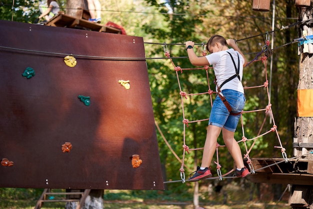 Il ragazzo supera l'ostacolo nel parco delle funi.