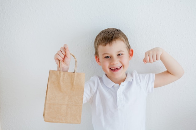 Il ragazzo tiene in mano un sacchetto di carta. Imballaggio ecologico. Eco.