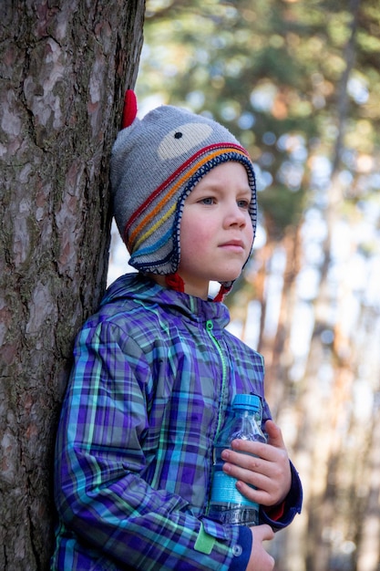 Il ragazzo trascorre un tempo felice all'aperto nella foresta godendosi la natura autunnale