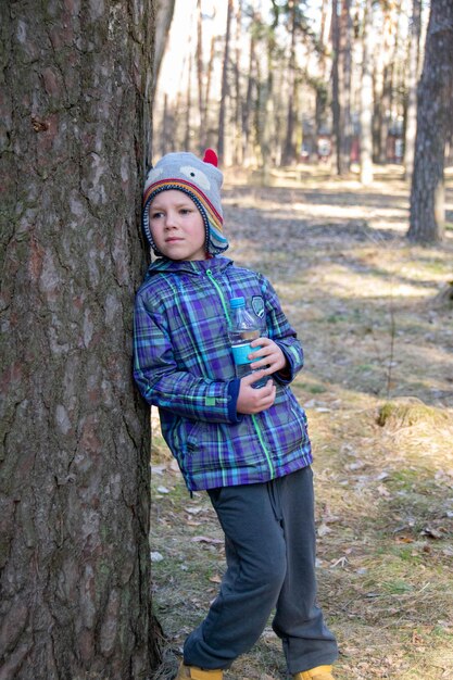 Il ragazzo trascorre un tempo felice all'aperto nella foresta godendosi la natura autunnale