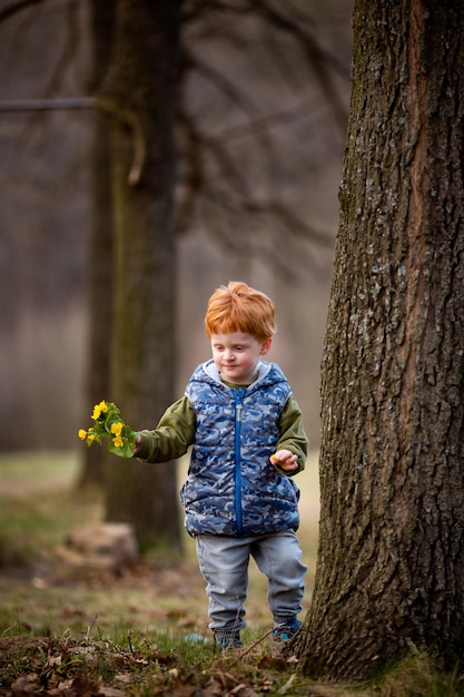 Il ragazzo ucraino cammina tra gli alberi in primavera