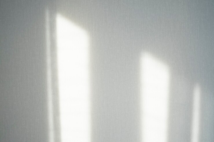 Il raggio di sole faceva un'ombra sul muro dalla finestra.