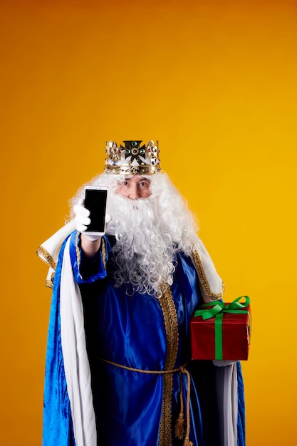 Il Re Mago che usa un telefono cellulare su sfondo giallo