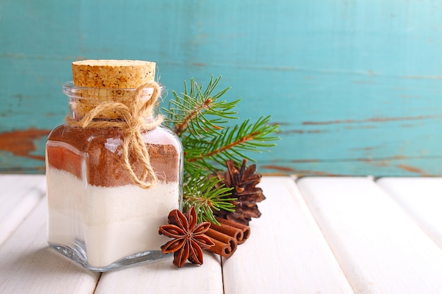 Il regalo di Natale asciuga la miscela in un vaso per la torta su una priorità bassa bianca e blu