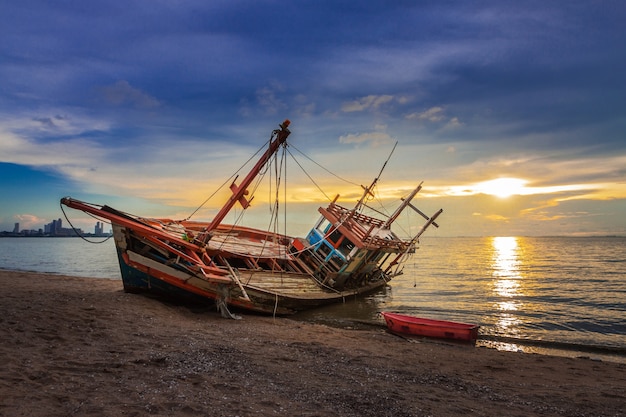 Il relitto è stato lasciato sulla spiaggia con il bellissimo cielo al crepuscolo.