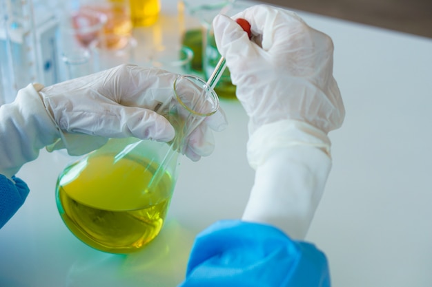 Il ricercatore sta lavorando con il liquido giallo del becher all&#39;interno