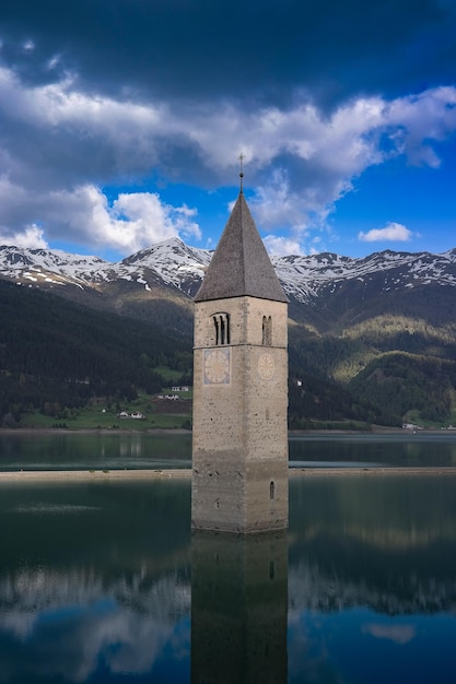 Il riflesso della torre sul lago contro le montagne