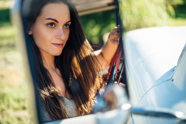 Il riflesso di una donna riflessiva nello specchio laterale