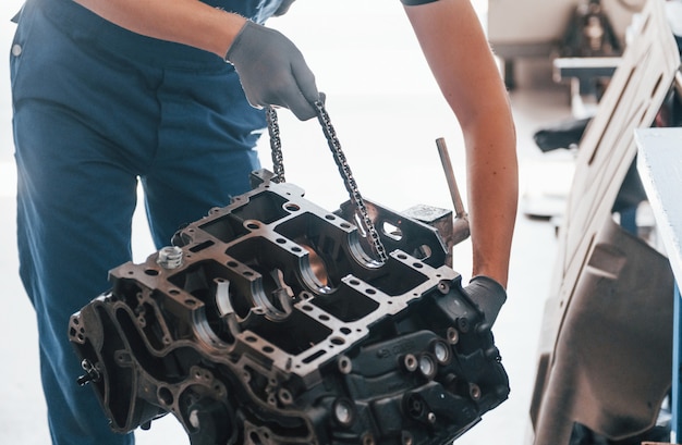 Il riparatore professionista lavora con il motore di automobile rotto