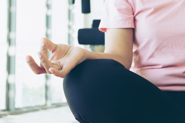 Il riscaldamento della donna di forma fisica asiatica prima fa l&#39;esercizio in palestra