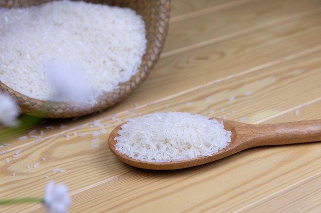 Il riso in un fondo di legno della siviera è un tessuto di canestro del contenitore sulla tavola di legno.
