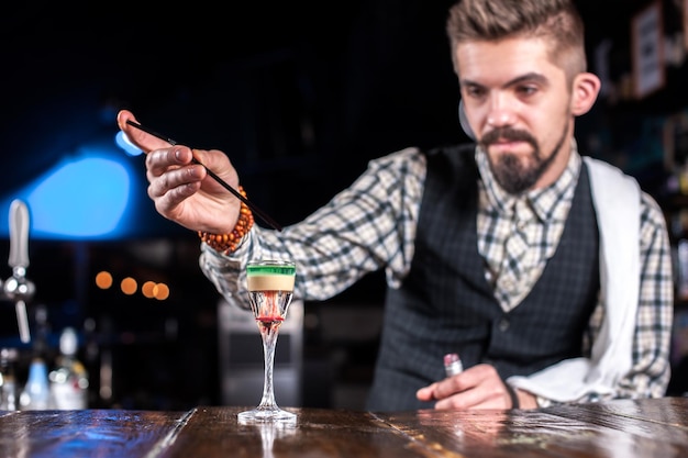 Il ritratto del barista sta versando un drink in discoteca