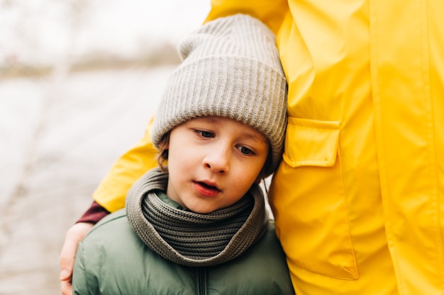 Il ritratto del figlio triste con il padre sta sulla riva del lago e tiene per mano la famiglia felice con