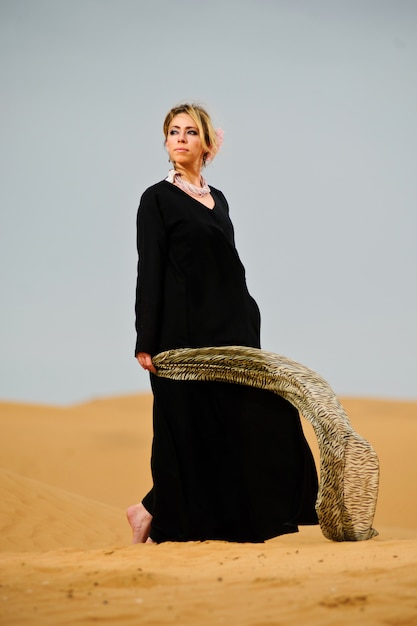 Il ritratto del modo arabo ha vestito la donna in deserto giallo