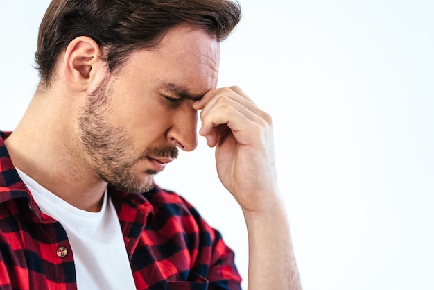 Il ritratto dell'uomo con il mal di testa sullo sfondo bianco