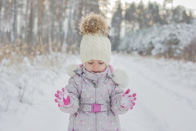 Il ritratto della bambina è una foresta innevata in inverno