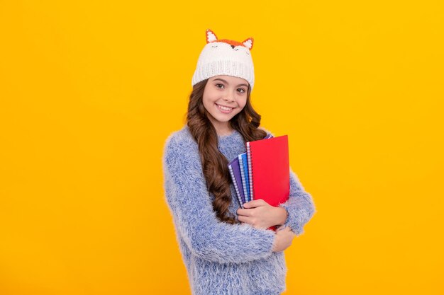 Il ritratto della cartella di lavoro della tenuta del bambino esprime la moda invernale di emozione positiva