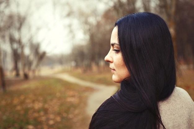 Il ritratto della donna castana con bei capelli lunghi spessi si chiude all'aperto