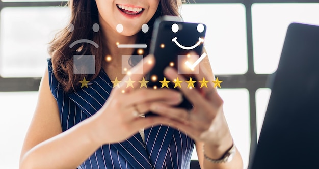 Il ritratto della donna del cliente utilizza lo smartphone e fornisce un feedback sull'icona del sondaggio sulla soddisfazione e il servizio clienti con il miglior servizio eccellente valutazione a cinque stelle.soddisfazione e concetto di servizio clienti