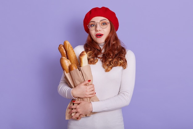 Il ritratto della donna sorpresa veste il berretto e il ponticello casuale bianco