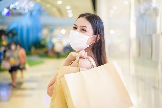 Il ritratto di bella donna sta indossando la maschera nel centro commerciale