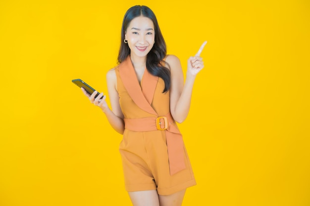 Il ritratto di bella giovane donna asiatica sorride con il telefono cellulare astuto