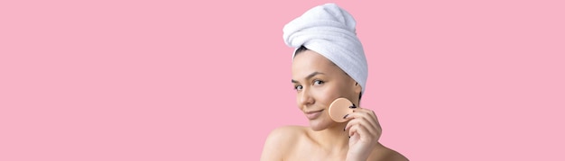 Il ritratto di bellezza della donna con un asciugamano bianco sulla testa applica la crema sul viso Detergente per la cura della pelle eco-cosmetico biologico spa relax concetto