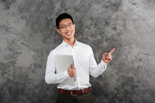 Il ritratto di giovane uomo asiatico sorridente si è vestito in camicia