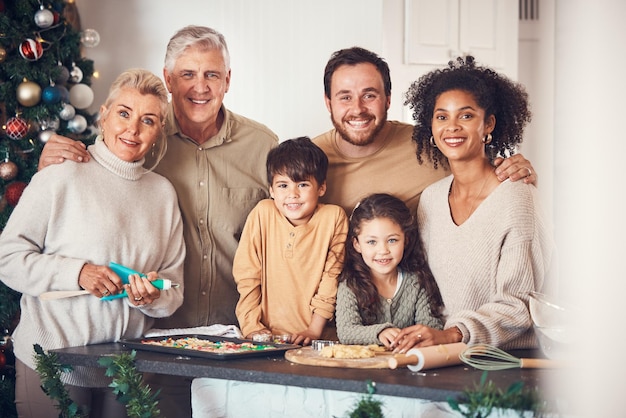 Il ritratto di Natale e la famiglia cucinano i biscotti nella cucina di casa e insieme cucinano il cibo di Natale e il volto felice dei nonni, dei bambini e dei genitori interrazziali alla festa o alle vacanze